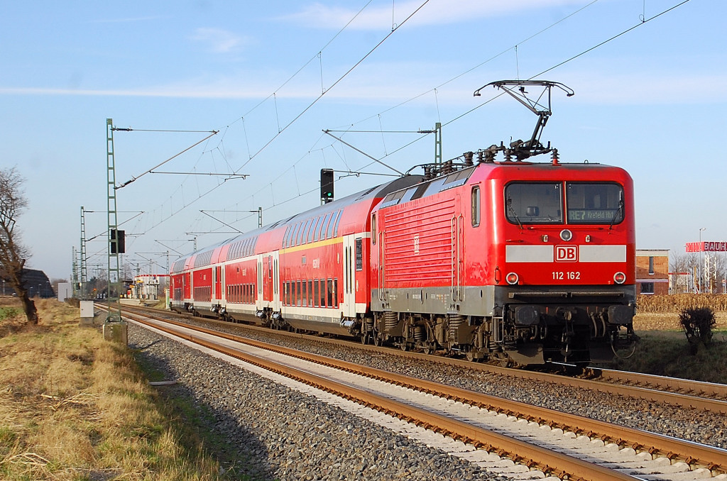  112 162 schiebt hier einen Dostockzug der Linie RE7