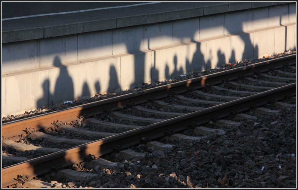 . Ein Schattenbild - Aufgrund der tiefstehenden Novembersonne fllt der Schatten einer Gruppe Bahnreisender auf die gegenberliegende Bahnsteigkante. Bahnhof Stuttgart-Bad Cannstatt. November 2011 (Matthias)