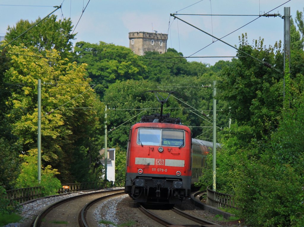 111 079-0 schiebt am 09.08.2012 den RE4 aus dem Haltepunkt Aachen Schanz nach Aachen West. Im Hintergrund der Aachener Pulverturm an der Turmstrasse. Mit dem Bau wurde im Jahr 1300 begonnen, er diente als Wehrturm der Stadtmauer und als Feuerposten. Seit 1951 wird er von Studenten mit einer wunderbaren Aussicht ber Aachen als Wohnraum genutzt.