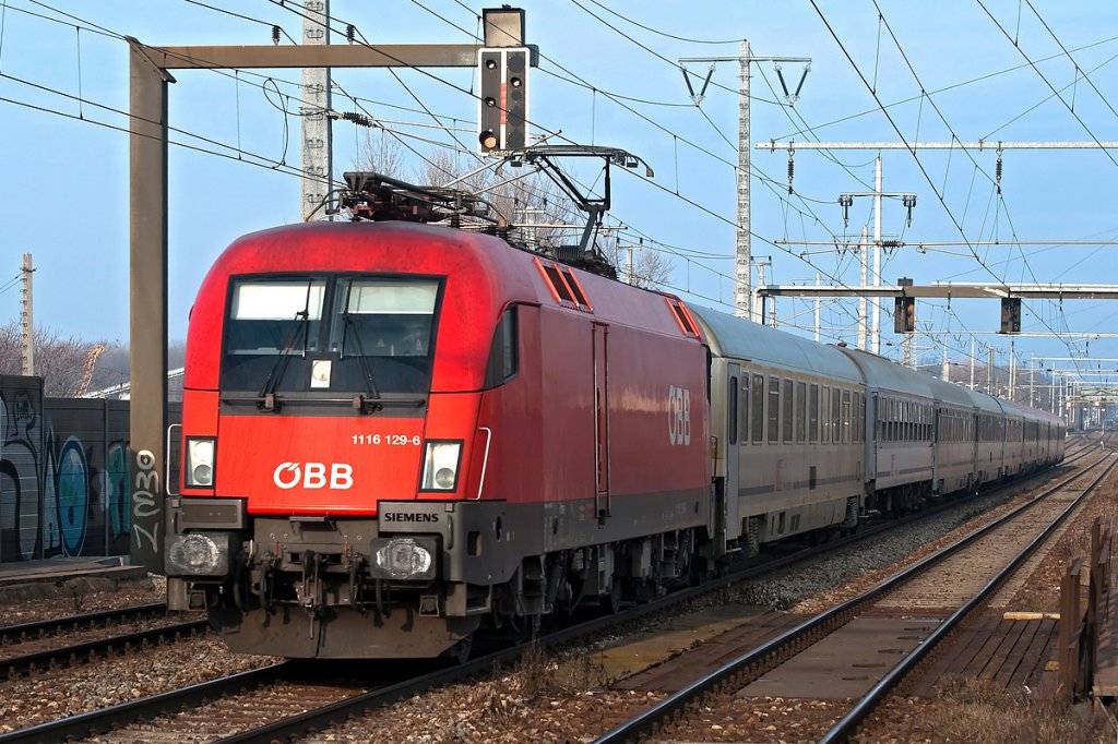 1116 129 bringt den EC 103  Polonia  nach Villach Hbf. Die Aufnahme entstand in Wien Haidestrae am 07.01.2011.