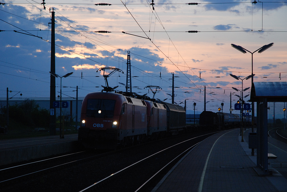 1116 157 und eine Schwestermaschine der Railion befrdern in der Abenddmmerung des 20.04.2008 einen Gterzug Richtung Osten durch den Bahnhof Gramatneusiedl.