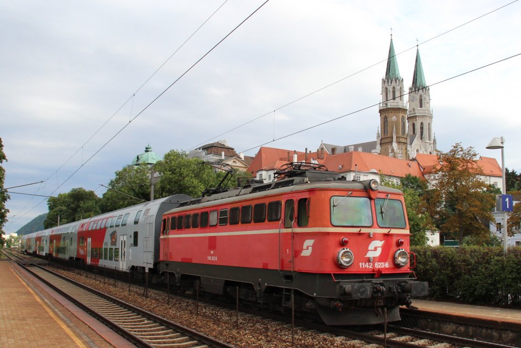 1142 623 mit dem REX von Wien Franz Josefs-Bahnhof nach Gmnd N, bei der Durchfahrt der Haltestelle Klosterneuburg-Kierling, im Hintergrund das Stift Klosterneuburg; am 12.07.2012
