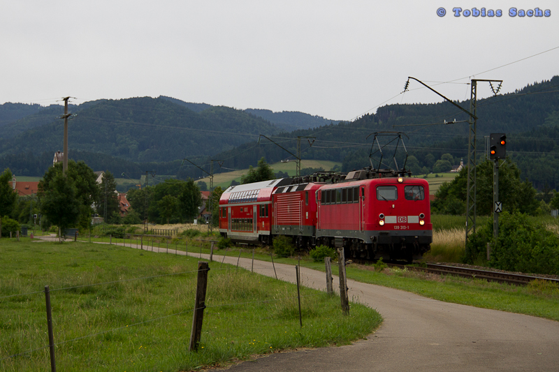 139 313 zog eine 143 856 und ein Doppelstockwagen als Lr 72170 nach Freiburg(Breisg) bei Kirchzarten am 24.06.2012. Es war beeindruckt, dass sie als Gast zur Hllentalbahn war. Aber das Wetter war leider schlecht und machte das Bild eher ungnstig.
