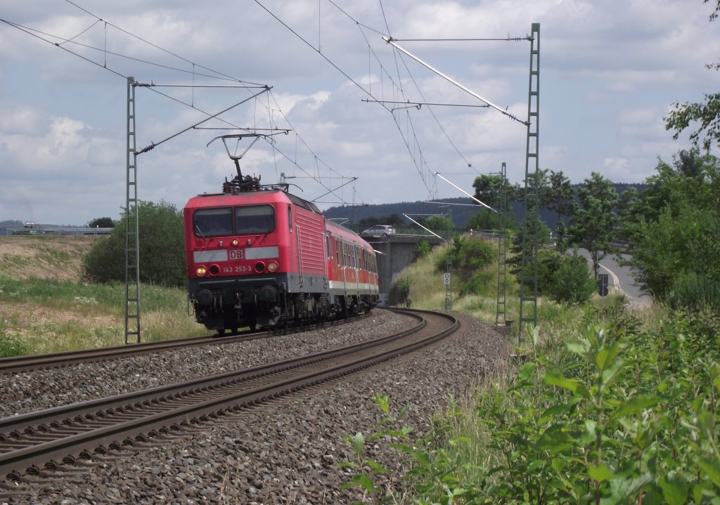 143 253-3 ist am 17. Juni 2011 mit defektem Steuerwagen und einer RB nach Bamberg auf der Frankenwaldbahn bei Neuses unterwegs.
