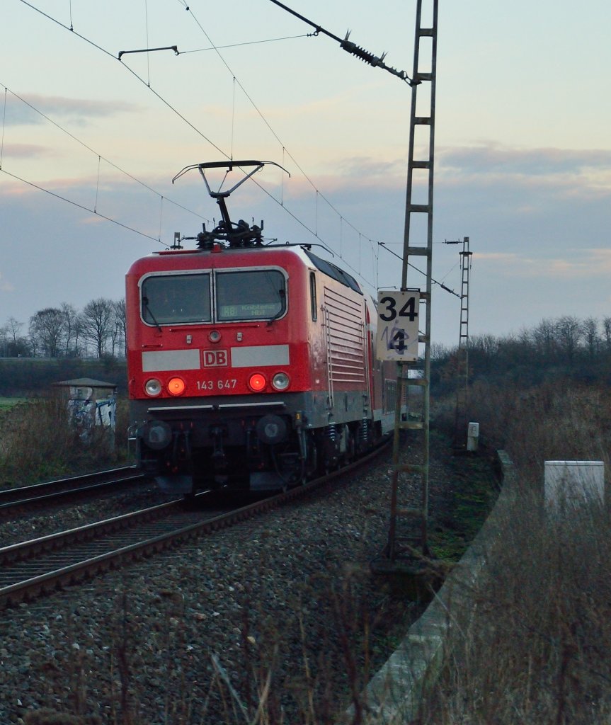 143 647 schiebt einen RB27 Zug am ehemaligen Bahnbergang zwischen Gierath und Grevenbroich an der Kbs 465 in Richtung Koblenz. 11.1.2013