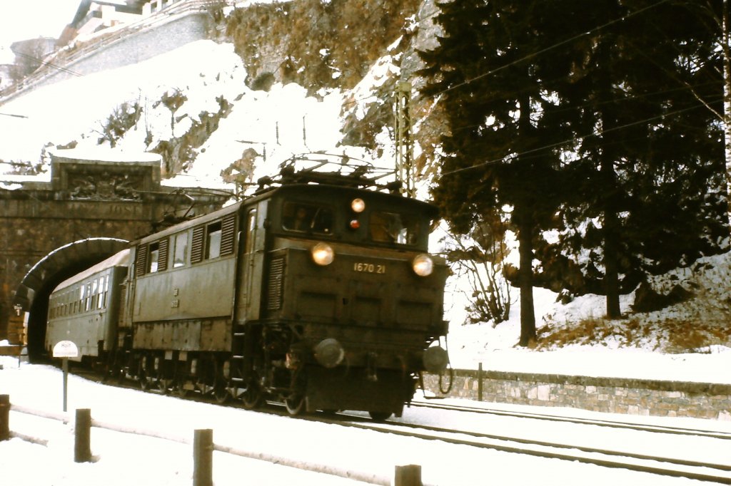 1670.21 verlt mit dem Personenzug aus Bludenz den Arlbergtunnel in St. Anton am Arlberg. Die Aufnahme entstand Mitte der 1970er Jahre in einer Woche zwischen dem 3. und 4. Advent, als das Wetter zu schlecht zu skifahren war.