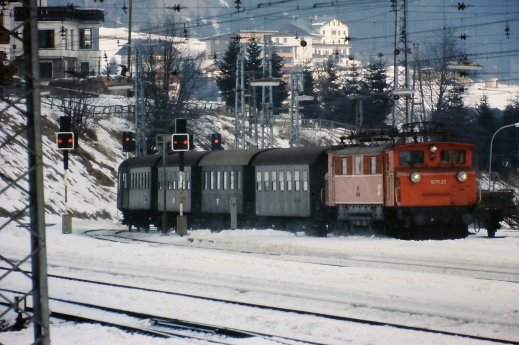 1670.23 bringt Mitte der 1970er Jahre den aus Plattformwagen gebildetem Personenzug aus Landeck nach St. Anton am Arlberg.