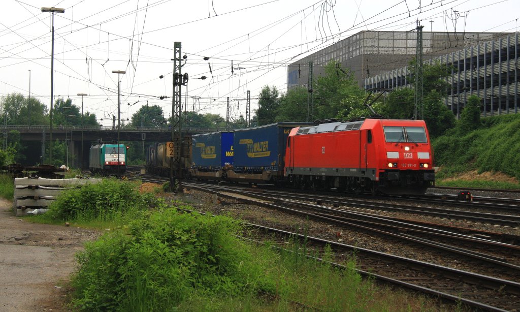 185 391-0 DB kommt aus Richtung Kln,Aachen-Hbf mit einem langen LKW-Cotainerzug aus Novara(I) nach Zeebrugge(B) und fhrt in Aachen-West ein und im Hintergrund steht die Cobra 2830 bei Wolken am 9.6.2013.