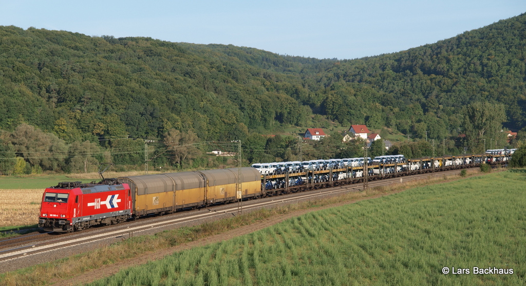 185 582-4 HGK rollt am 6.09.12 mit einem ARS-Autozug durch das morgendliche Maintal bei Harrbach Richtung Wrzburg.