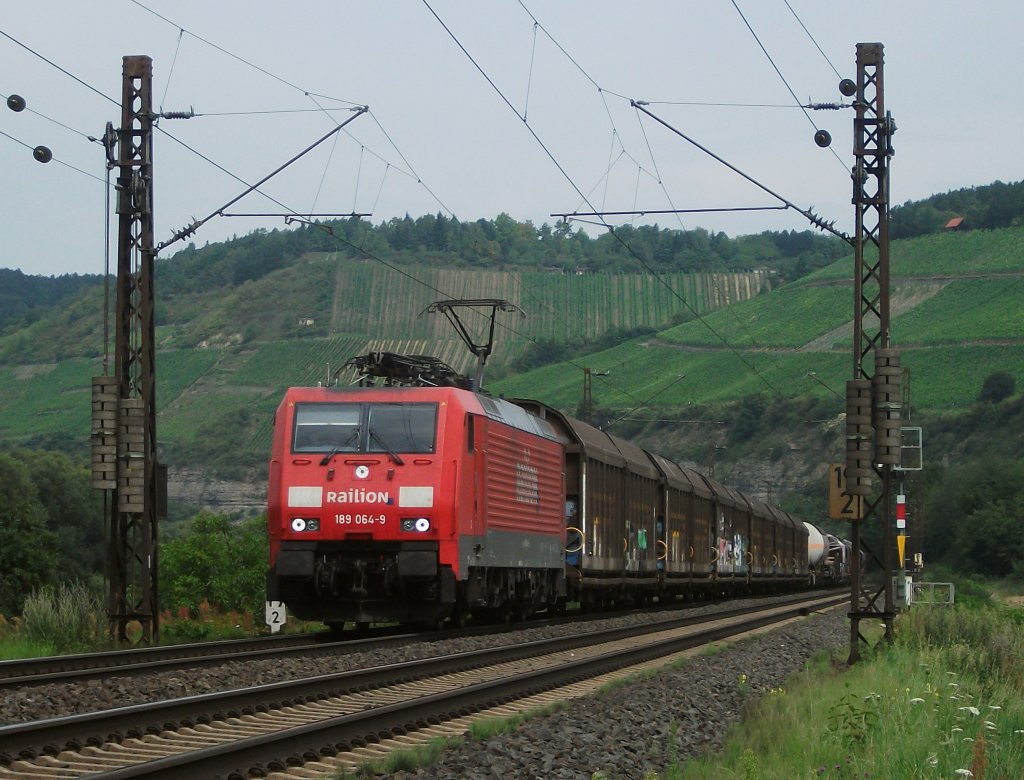 189 064 ist am 03.August 2011 mit einem gemischten Gterzug bei Himmelstadt unterwegs.