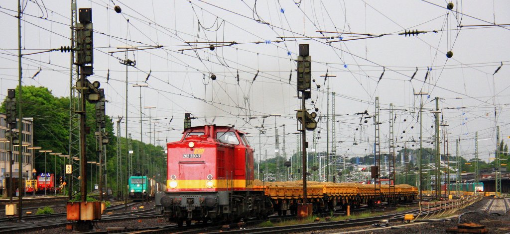 202 330-7 der EBM rangiert in Aachen-West mit einem kurzen Schotterzug und im Hintergrund steht die 185 577-4 von Crossrail mit einem langen Containerzug und wartet auf die Abfahtrt  nach Italien ber Kln bei Regenwetter am Abend vom 28.5.2013.