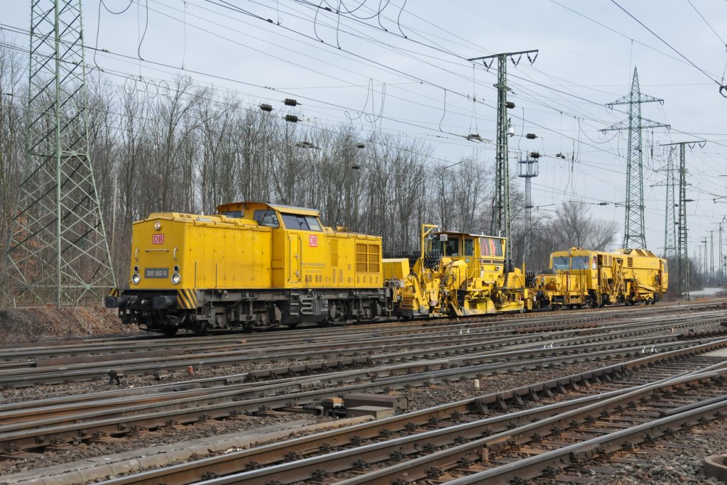 203 302-5 der DB-Netzinstandhaltung zieht einen Gleisbauzug durch Kln-Gremberg. Aufgenommen am 26/02/2011.