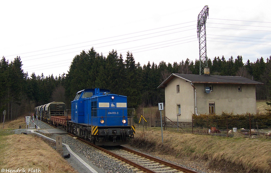 204 013 ist am 01.04.2010 mit einem Schotterzug nach Cranzahl Richtung Chemnitz unterwegs. Der Schotter wurde im tschechischen Bahnhof Vejprty (zu deutsch Weipert) in die Wagen geladen.