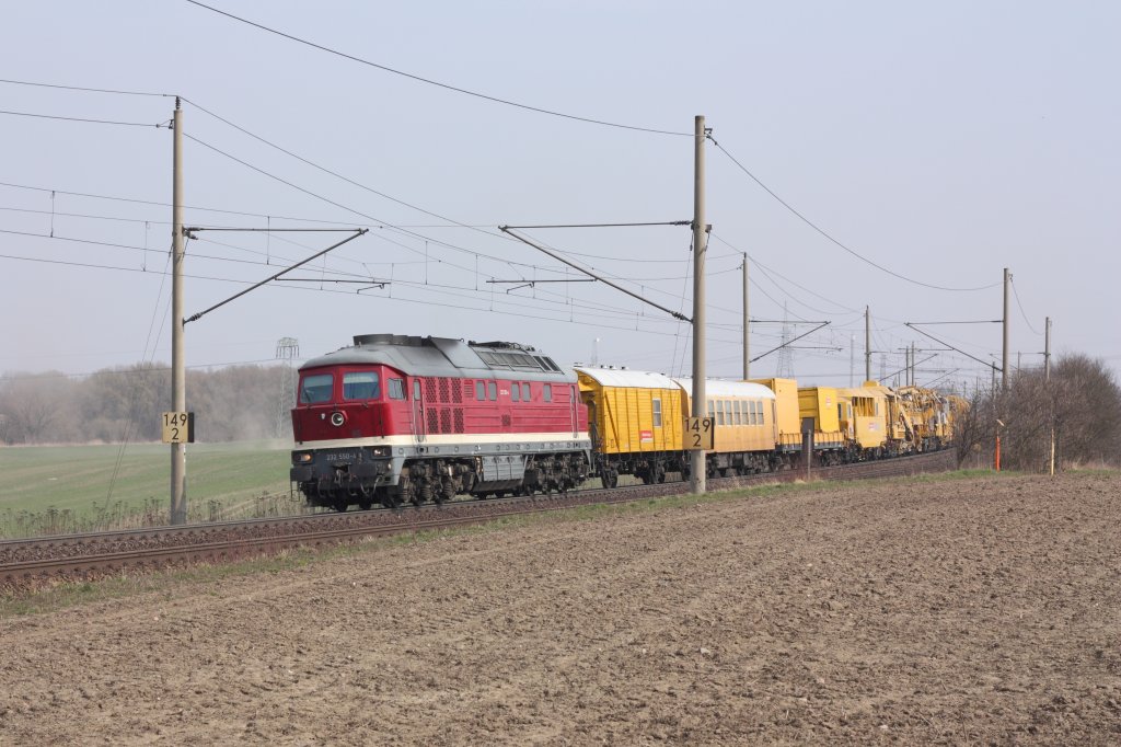 232 550-4 der DGT fhrt auf der KBS310 mit einem Bauzug in Richtung Braunschweig. Fotografiert am 30.03.2011 zwischen Magdeburg und Niederndodeleben in Hhe der Autobahnbrcke der A14. 