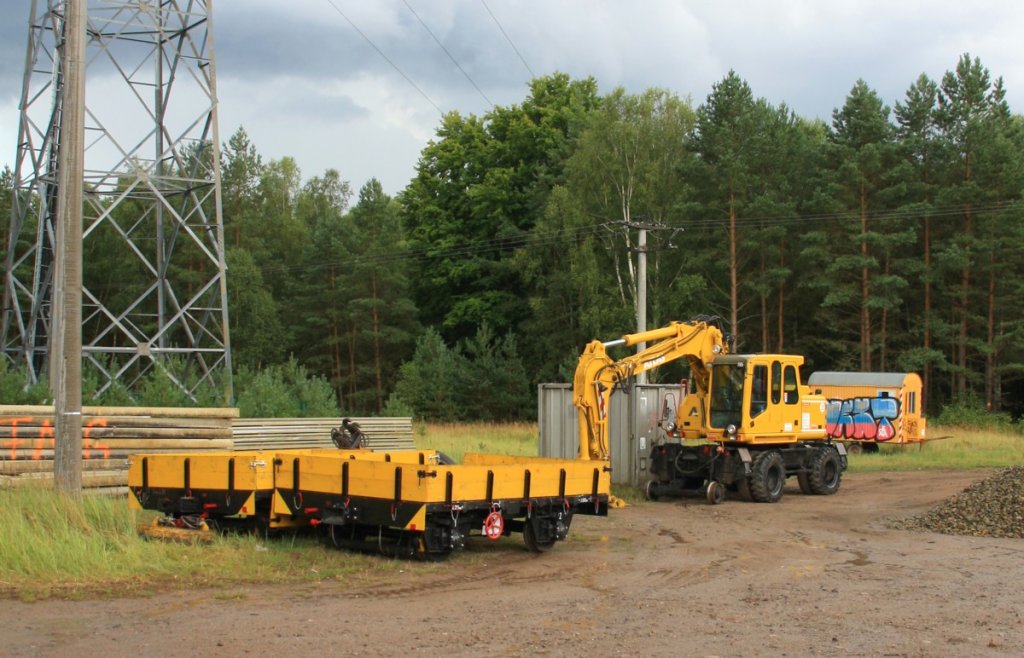 26.8.2012 Dsterfrde, Berliner Nordbahn. Zweiwege-Bagger und Kleinwagen warten abseits der Gleise auf ihren Einsatz.