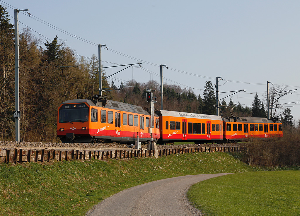 65-Promille-Rampe (siehe Tafel links). Be 556 und Zwischenwagen der S10/Uetlibergbahn befahren gerade dieses Teilstck talwrts und erreichen in wenigen Augenblicken die Station Ringlikon, 17. April 2010, 18:31