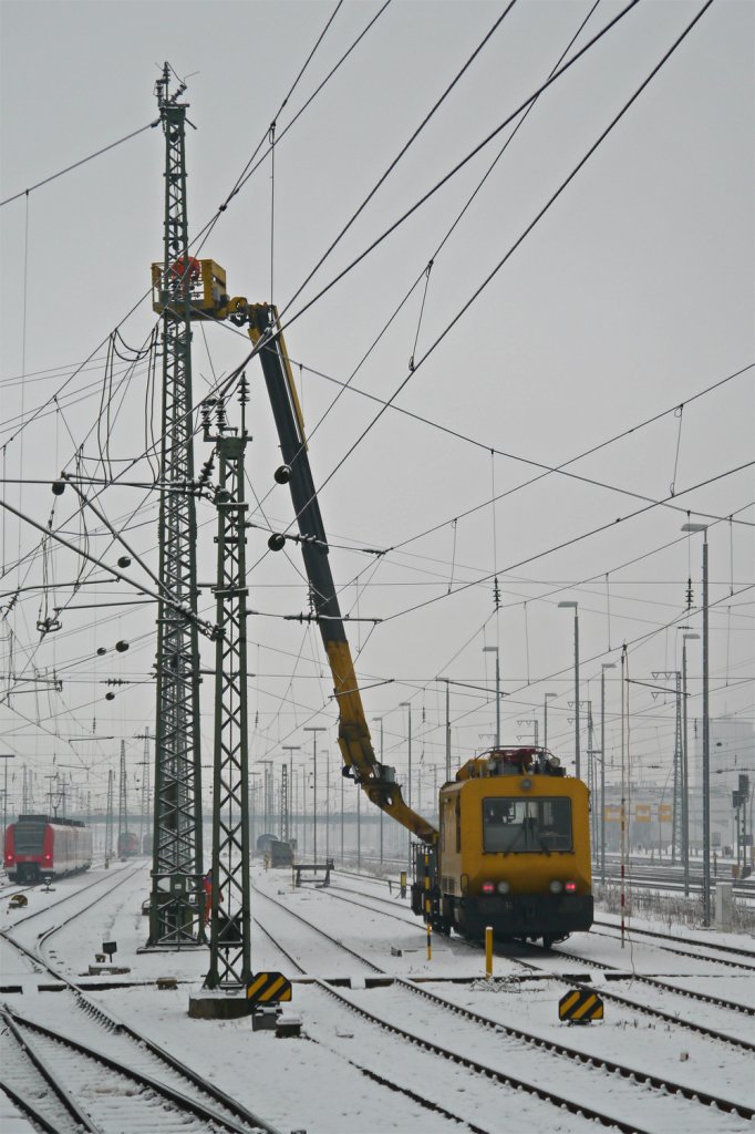 703 102-4 ist am 15.02.2013 mit Wartungsarbeiten an der Oberleitung in Mannheim beschäftigt. Zuerst wurde der Abschnitt vom Netz getrennt und dann mit Erdungsstangen geerdet, bevor es an die Arbeit ging. 
Diese Höhe hätte ich diesem Mini-Diesler gar nicht zugetraut, aber so kann man sich irren...
