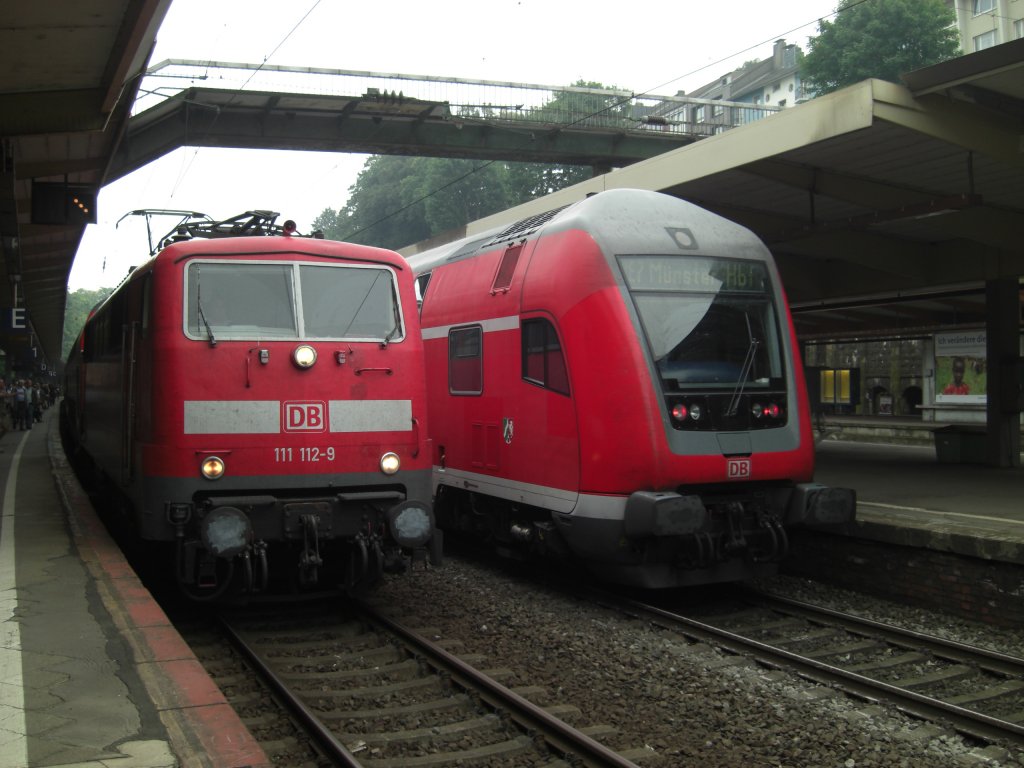 8.8.09, Wuppertal Hbf. Die 111 112 fhrt mit dem RE4 ein, daneben wartet ein RE7 auf die Ausfahrt.