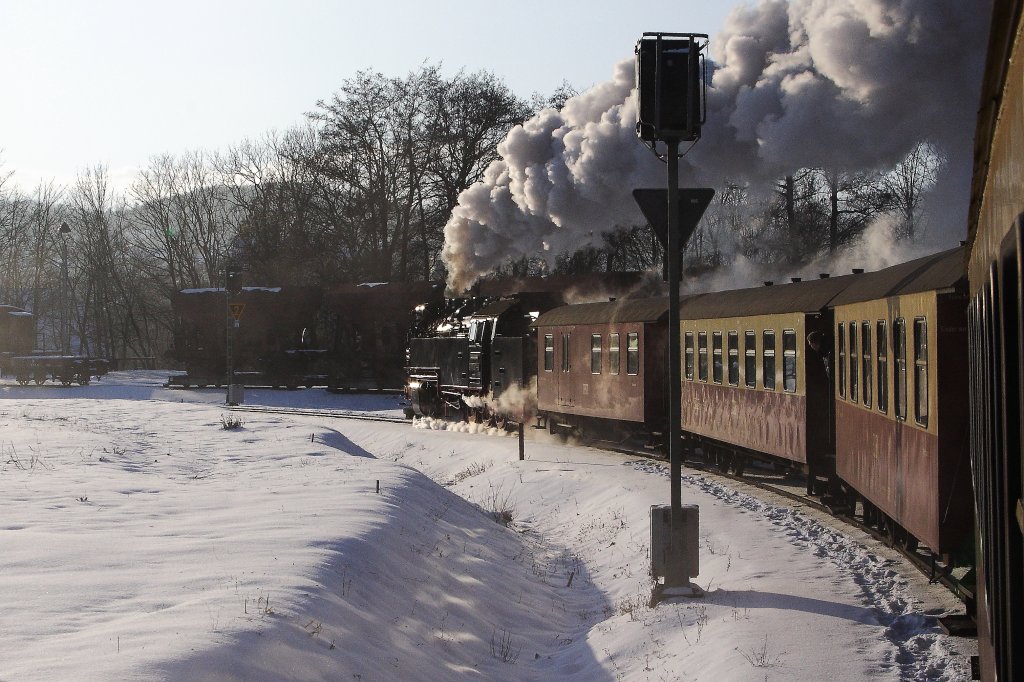 99 7237 mit P8937 in Richtung Brocken, aufgenommen am 25.01.2013. Die Lok befindet sich hier gerade zwischen zwei Lichtsignalen. Das vordere ist das Einfahrtssignal fr den Bahnhof Wernigerode, das hintere entsprechend fr den Bahnhof Wernigerode-Westerntor, welchen wir mit unserem Zug auch gleich erreichen werden. Hinten im Schatten sind Rollwagen mit geladenen Regelspurwaggons zu erkennen.