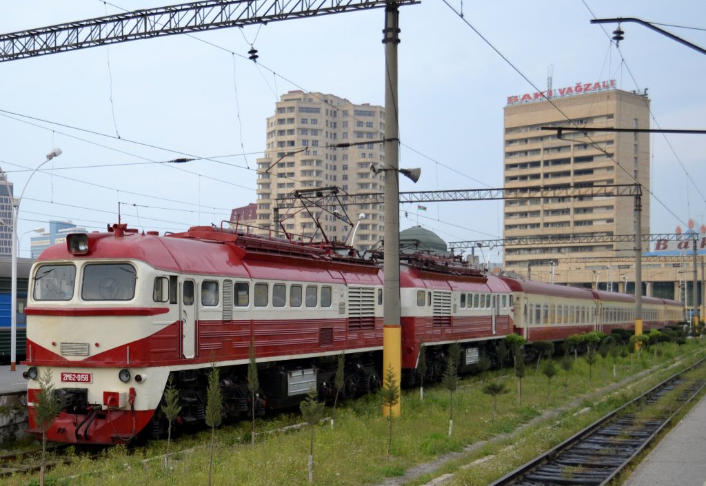 Am 17.4.2012 wartet im Bahnhof Baku die E2M62 0185 mit dem Ex 602 auf die Abfahrt nach Gence. Sie ist einzigartig: 1995 wurde aus 2 dieselelektrischen Loks 1 Elektro-Lok zusammengebaut. Die Lackierung in den Farben des aserbaidschanischen Prachtzuges drfte auch noch nicht so alt sein. Stationiert ist sie in Gence.