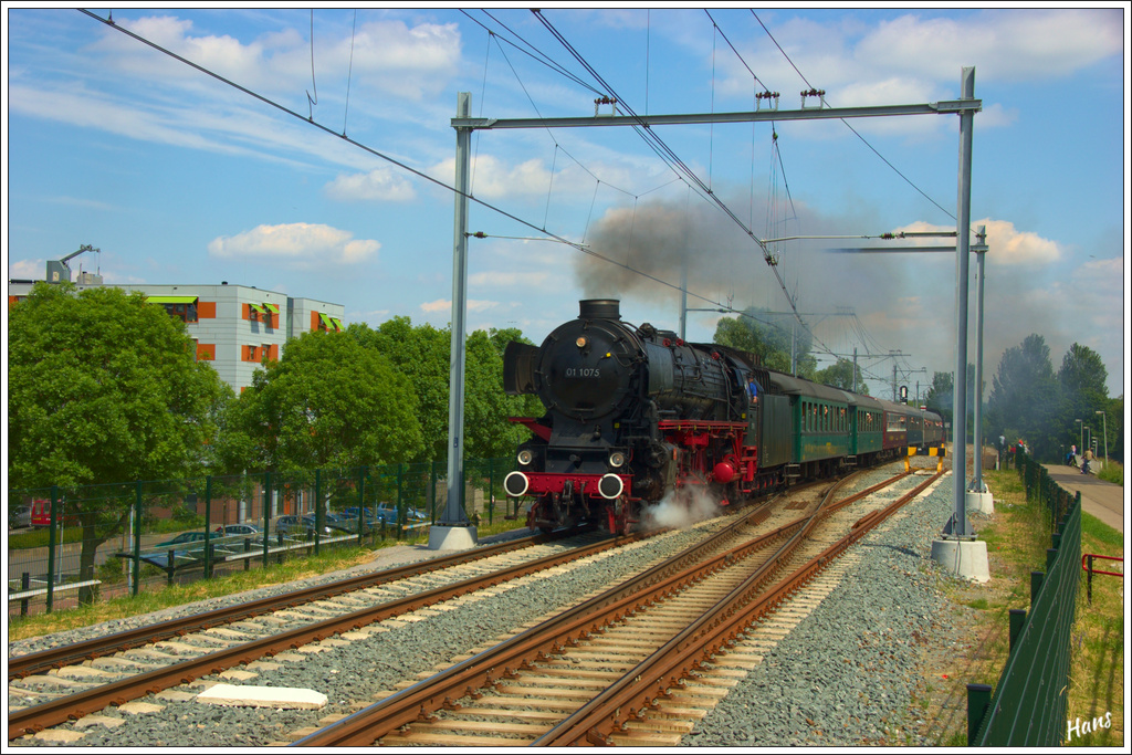 Am 2. Juni 2012 fand in Dordrecht eine groe Dampfveranstaltung statt, wobei viele Dampfmaschinen zu betrachten waren. Auch zwei Dampflokomotiven waren im Einsatz, die 01 1075 und 65 018 der Stoomstichting Niederlande. Hier ist der durch diese beiden Lokomotiven gezogene Zug auf einer der Pendelfahrten unterwegs beim Bahnhof Dordrecht Stadspolders.