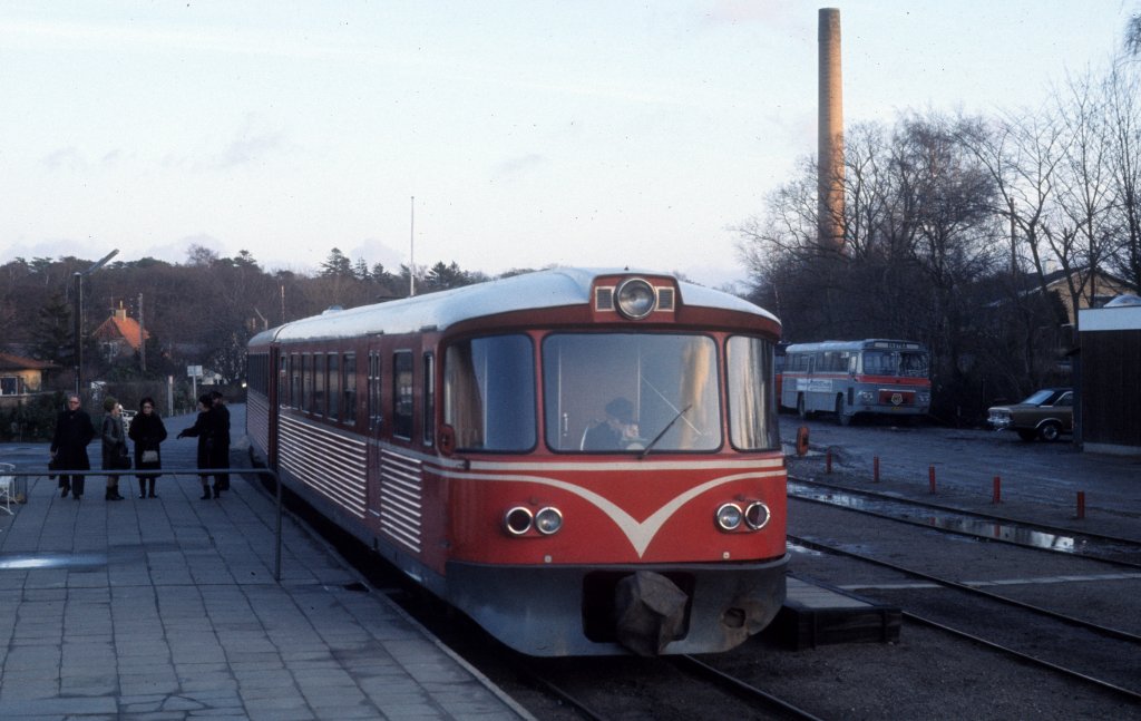 Am 25. Dezember 1974 hält ein Zug der HHGB, Helsingør-Hornbæk-Gilleleje-Banen, am Bahnhof Hornbæk. - Der Zug, der aus einem Triebwagen (Ym) und einem Steuerwagen (Ys) besteht, wird kurz nach der Aufnahme des Fotos seine fahrt nach Gilleleje fortsetzen. - Auf der Bahnstrecke Helsingør - Hornbæk - Gilleleje fahren heute LINT 41-Triebzüge der Bahngesellschaft Lokalbanen, die auch andere Bahnen in Nordseeland besitzt.