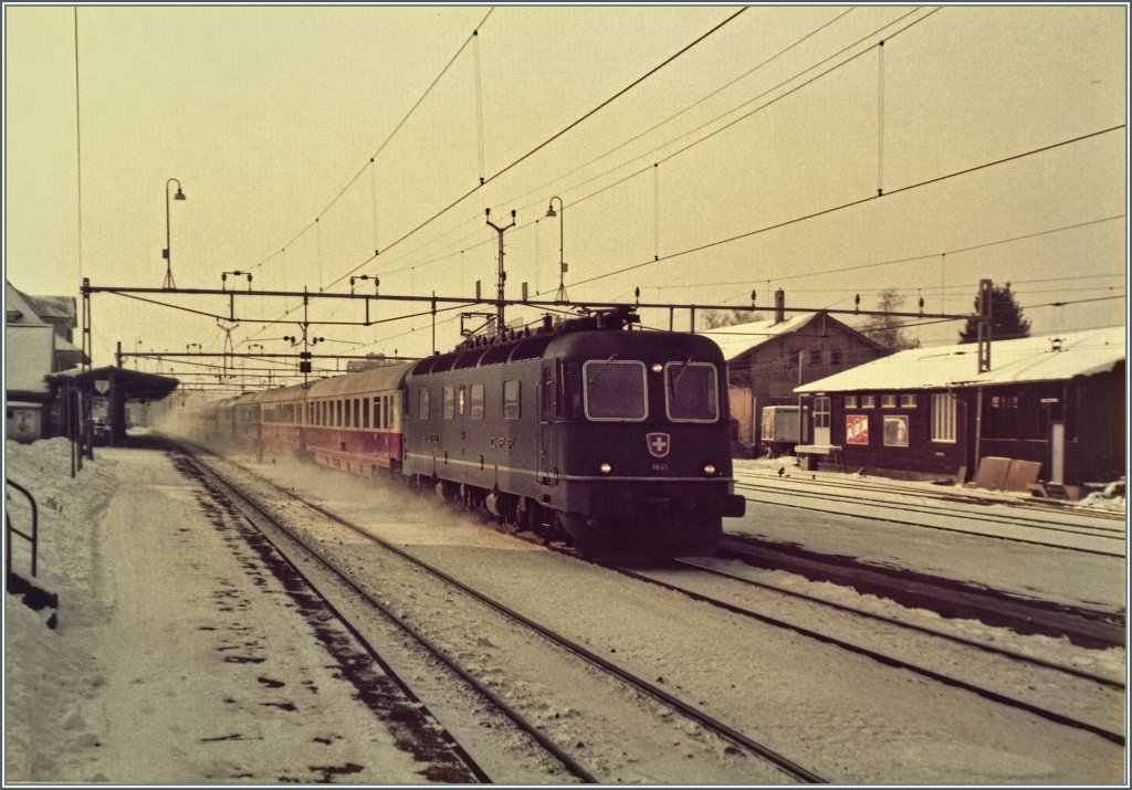 Am 8. Januar 1985 zieht die SBB Re 6/6 11645 den Eurocity  Mont-Blanc  von Genve nach Hamburg durch den leicht verschneiten BLS/MLB Bahnhof von Grenchen Nord.