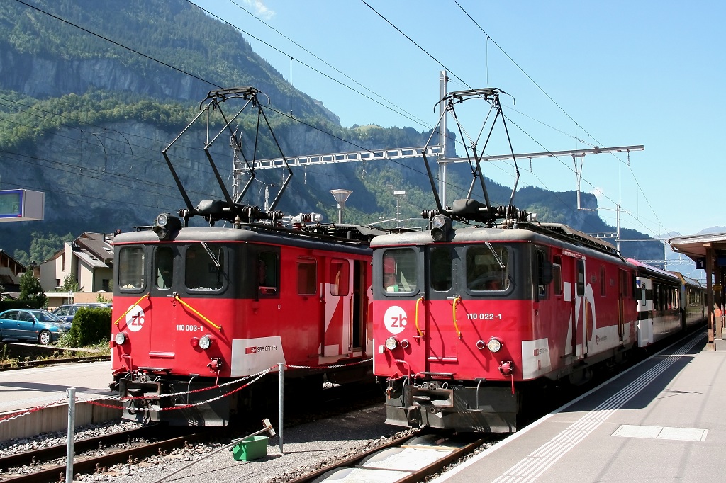 Bahnhof Meiringen 2012. De 110 003-1 mit Zug nach Interlaken Ost und der gerade eingefahrende Golden Pass Panoramic mit De 110 022-1. Nach dem Abkuppeln der Tallok (De) und dem Ankuppeln der Berglok (HGe) an der anderen Seite des Zuges, fahren dann beide Zge zeitgleich aus dem Bahnhof.
