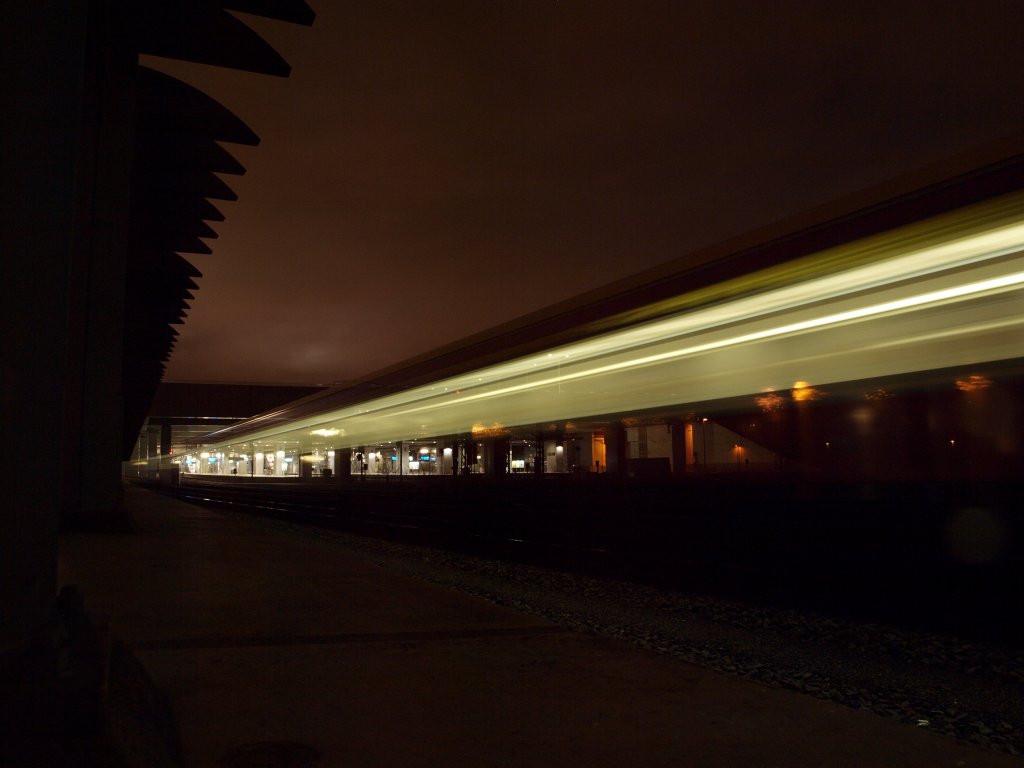 Bahnhof Sdkreuz bei Nacht: die Lichtspuren einer S-Bahn und der von der stdtischen Beleuchtung angleuchtete regnerische Nachthimmel ergeben eine interessante Lichtszenerie.