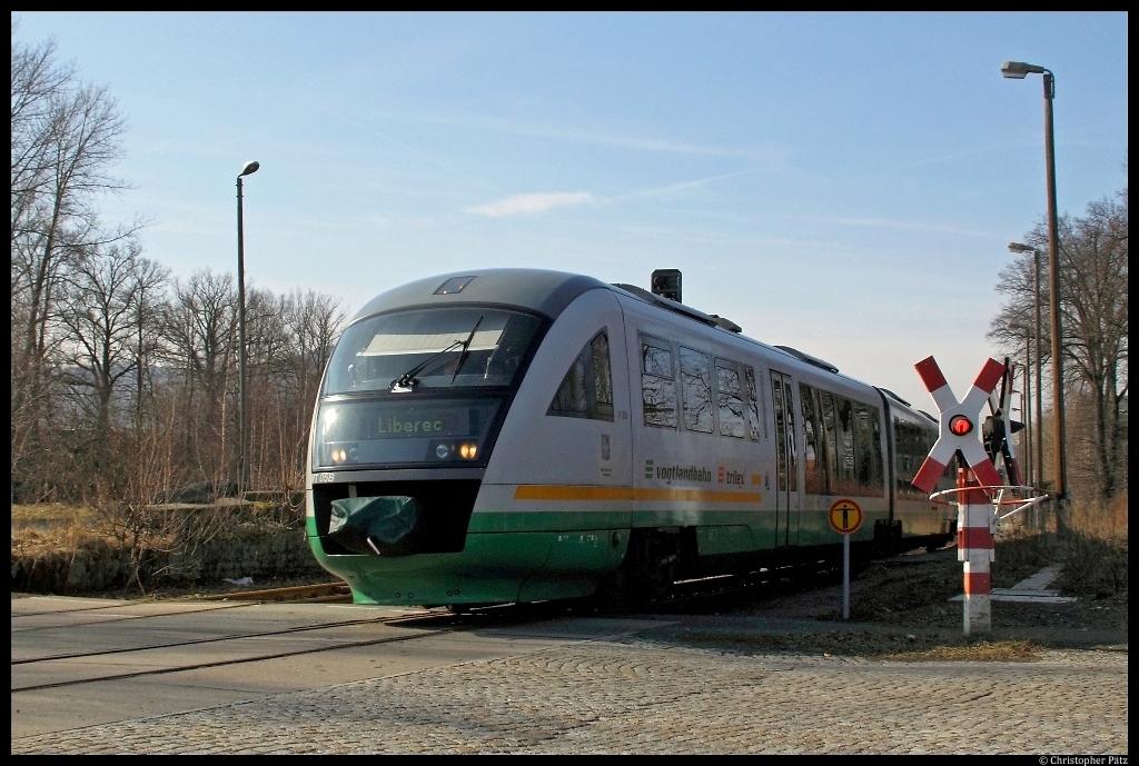 Bei der Ausfahrt aus dem Bahnhof Groschnau berquert VT 05 der Vogtlandbahn einen mit einer Haltlichtanlage der Bauform HL-64b gesicherten B. Der Zug fhrt als Trilex ber Zittau nach Reichenberg/Liberec. (3.3.2012)