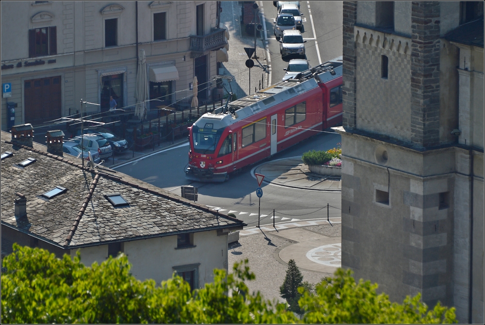 Berninabahn in Tirano.

Langsam fährt der Allegra über den Kreisverkehr auf dem Kirchplatz. Im Hintergrund ein Restaurant mit Logenplatz für den Bahnfan.

Im Juli 2013.