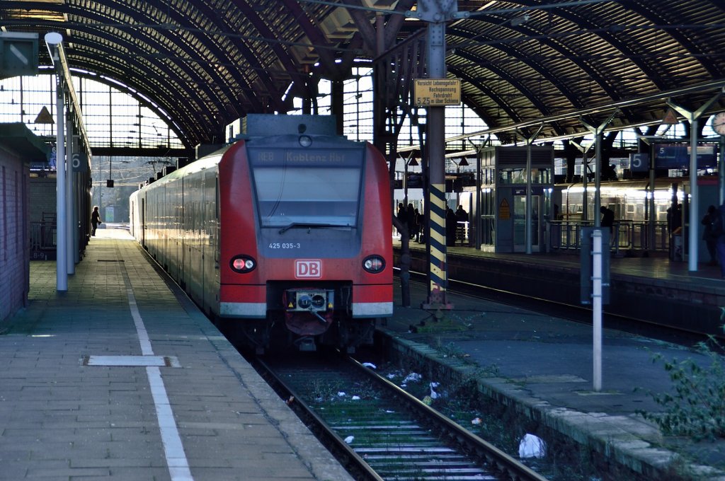 Blick in die Bahnsteighalle des Mnchengladbacher Hauptbahnhofes, auf Gleis 6 steht ein abfahrbereiter RE8 Zug an dessen Ende der 425 035-3 zu sehen ist und der von hieraus nach Koblenz aufbricht.13.1.2013