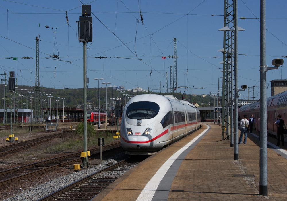 Der Fernverkehr von und nach Saarbrcken wurde in den letzten Jahrzehnten kontinuierlich aus gednnt. Die 5 ICE/TGV Zugpaare zwischen Paris und Frankfurt/Main, sowie noch vereinzelte IC/EC aus/nach Stuttgart oder Graz haben die Quantitt der Fernverbindungen verringert.

ICE 3 nach Paris hat fast pnktlich Ausfahrt auf Gleis 12 des Hbf. Saarbrcken. ICE nach Frankrfurt hatte vor 5 Minuten den Bahnhof in die Gegenrichtung verlassen. Rechts wartet der RE nach Koblenz auf Anschlussreisende.

Der linke Bahnsteig im Hintergrund (Gleis 17 und 19) wird nicht mehr von Reisenden genutzt.
Bei der Neugestaltung wurde der Zugang zugemauert und die Durchgangsgleise bekamen einen Prellbock und knnen nur noch in eine Richtung befahren werden. Eigentlich eine unsinnige Manahme, erstens beraubt man sich Expansionsmglichkeiten und bei Belegung von allen Gleisen wie hier gegen 15.00 mssen die Fahrgste zum RE nach Koblenz, wenn der Himmel weint, durch den Regen laufen.
28.04.2012