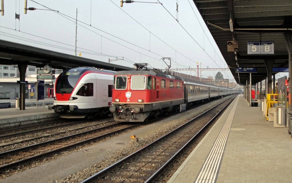 Der RABe 523 020 steht am 09.04.10 als S1 nach Baar bereit fr v. A. Pendler, whrend die Re 4/4 11225 eher einen touristischeren IR Luzern-Locarno zieht. Die Bezeichnung Basel-Locarno wrde wieder mehr mit Berufsverkehr zu tun haben.