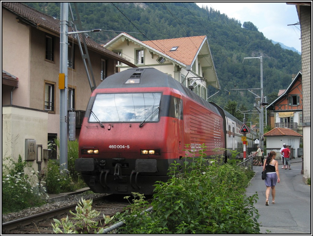 Ein SBB-Zug mit RE 460 004 passiert einen Bahnbergang im Zentrum von Interlaken. Das Bild zeigt, wie eng es an diesem eingleisigen Streckenabschnitt zwischen den beiden Bahnhfen Interlaken West und Ost zugeht. Die Aufnahme entstand am 16.07.2010.