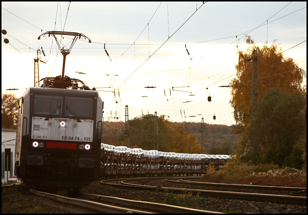 Eine neue Ladung sportlicher AUDIS fr die Straen in bersee: E189 111 (ES64F4-911) hat wieder einen langen  AUDI-Express , Ingolstadt-Nord - Osnabrck Rbf, am Haken und musste eine berhollung durch einen ICE abwarten. Hier verlsst der Zug Westhoven in Richtung Schwerte(Ruhr). (29.10.2010)