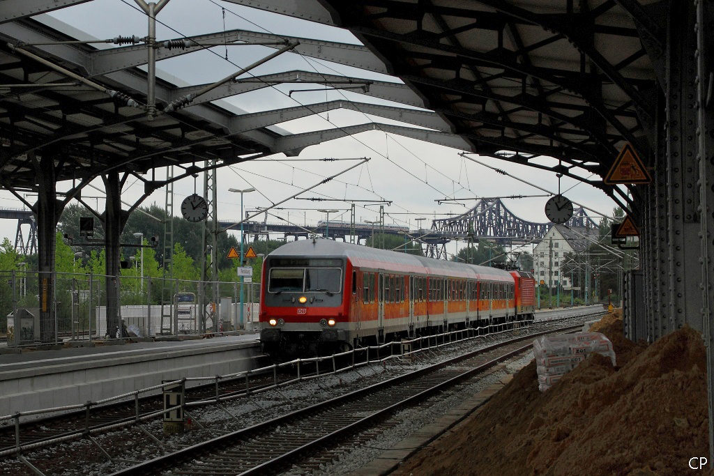 Eine RB nach Flensburg erreicht geschoben von einer 143 den Bahnhof Rendsburg. Im Hintergrund passiert ein ICE-TD die Hochbrcke. (22.8.2010)