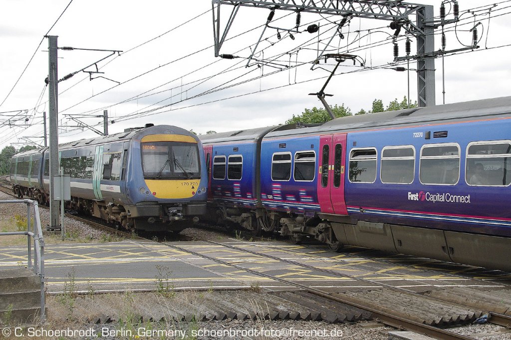 Ely (Cambridgeshire), northbound National Express EMU 170 270 meets southbound First Capital Connect at levelcrossing. 07,07,2010