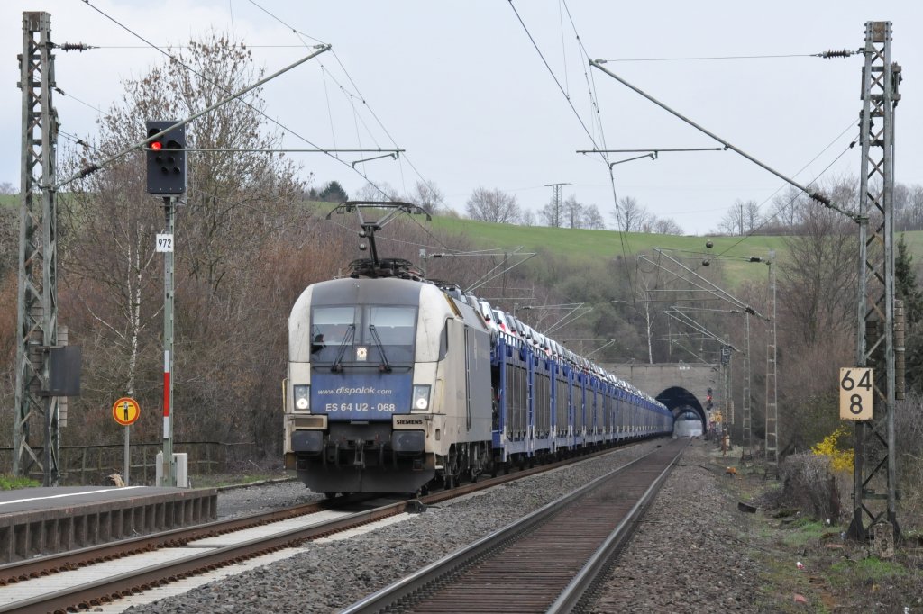 ES 64 U2-068 der WLB zieht einen langen Autoganzzug durch den Haltpunkt Eilendorf in Richtung Aachen-West. Lok und Zug bilden hier eine schne Farbeinheit. Aufgenommen am 26/03/2011.