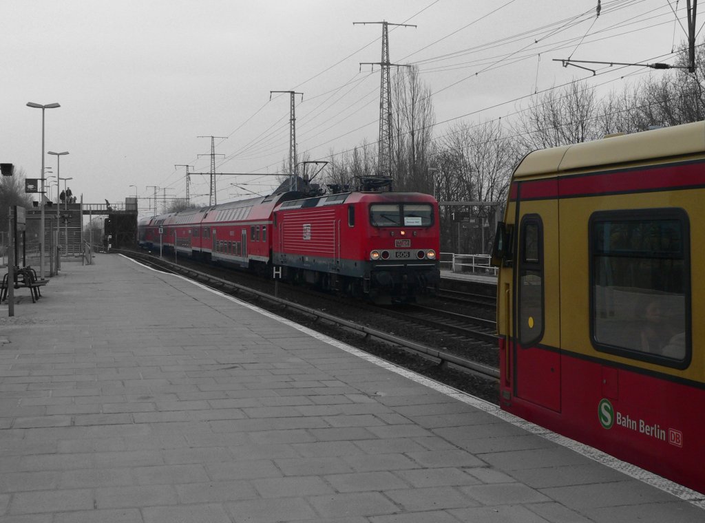 Farbkleckse an einem grauen Tag: MEG 606 und eine S-Bahn der BR 481 am 27.2.2011 in Berlin Karlshorst. Dies war der letzte Tag eines sogenannten Winterfahrplans, bei dem die ursprnglich fr 100 km/h konzipierten S-Bahn-Zge sicherheitshalber nur noch mit 60 km/h fahren durften. Eine Privatlok im DB-Regionalverkehr hinterlsst ebenso einen komischen Eindruck.