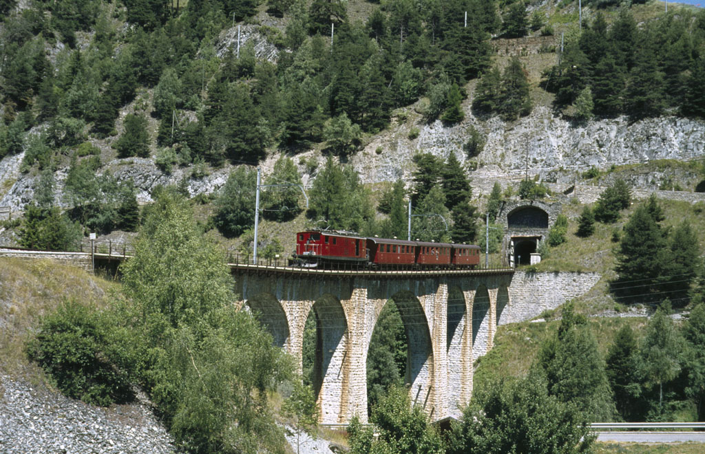 FO HGe 4/4 I Nr. 31 mit alten Personenwagen mit offener Plattform auf Grengiols-Viadukt, aufgenommen im Sommer 1979