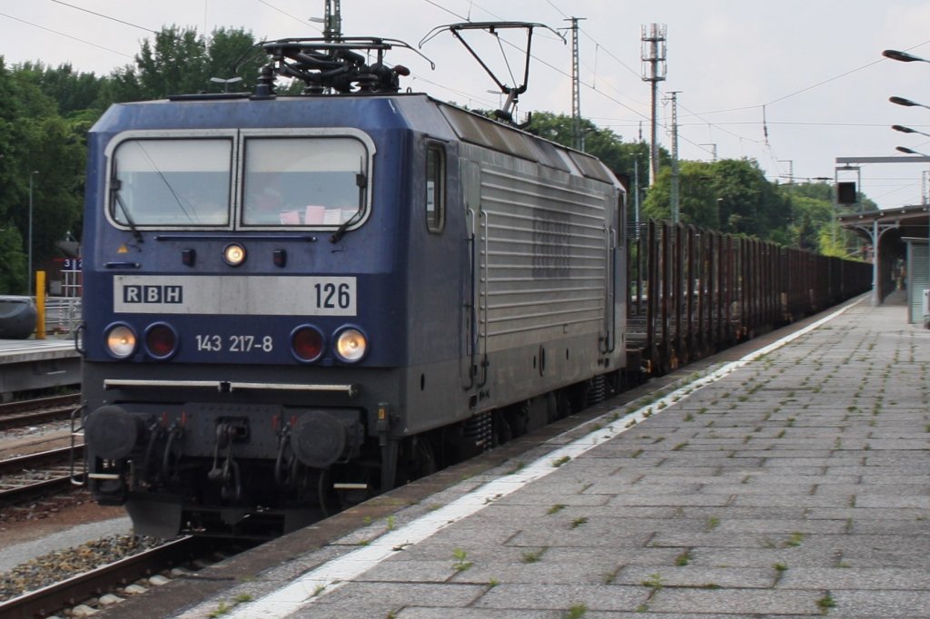 Hier 143 217-8 mit einem leeren Holzzug, bei der Durchfahrt am 28.6.2013 durch Berlin Wannsee, in Richtung Berlin Grunewald.