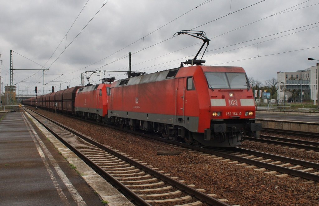 Hier 152 164-0 und 152 058-4 mit einem Schttgutwagenzug, bei der Durchfahrt am 27.4.2013 durch Berlin Schnefeld Flughafen, in Richtung Wnsdorf-Waldstadt.
