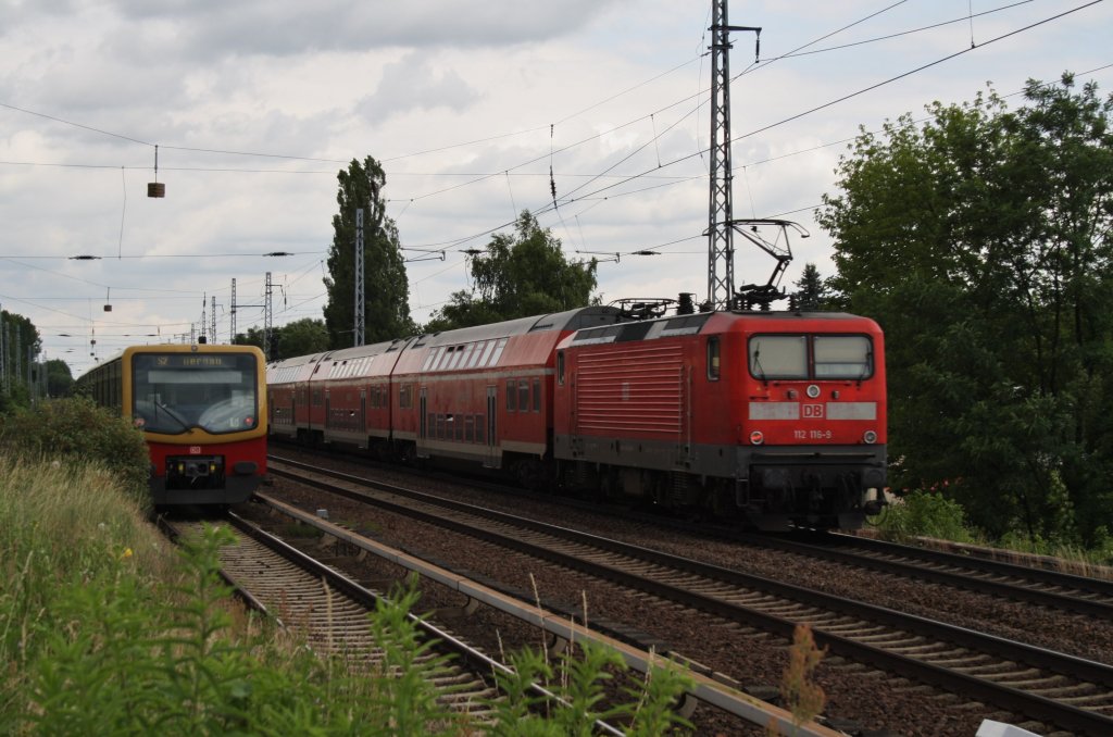Hier links 481 211 als S2 von Berlin Lichtenrade nach Berlin Buch und rechts 112 116-9 mit einem RE3 (RE18312) von Elsterwerda nach Stralsund Hbf., dise beiden Zge begegneten sich am 27.6.2013 in Berlin Karow. 