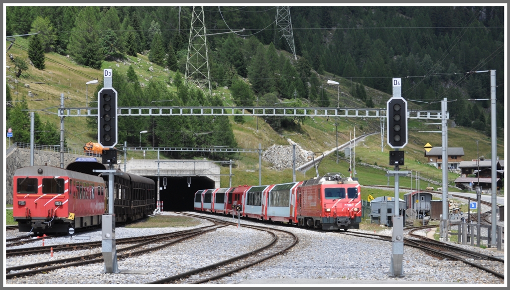 Impressionen aus Oberwald. Glacier Express 905 mit HGe 4/4 II fhrt ohne Halt durch den Bahnhof, links ein Steuerwagen des Autozuges durch den Furka Basistunnel nach Realp. Rechts ber der Lok ist die Furka Bergstrecke und das Verbindungsgleis zur DFB sichtbar.(21.07.2011)