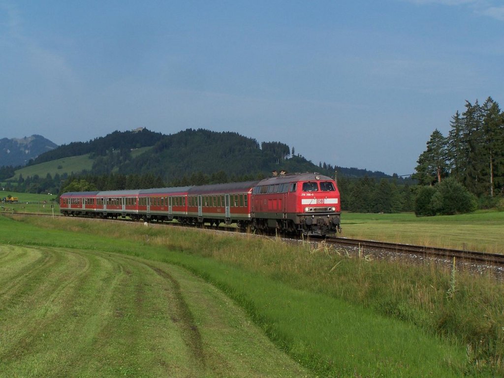 In der Kulisse der Eisenberg Burgruine fhrt die 218 396 am 03/08/11 an der Gemeinde Hopferau nach Fssen vorbei.