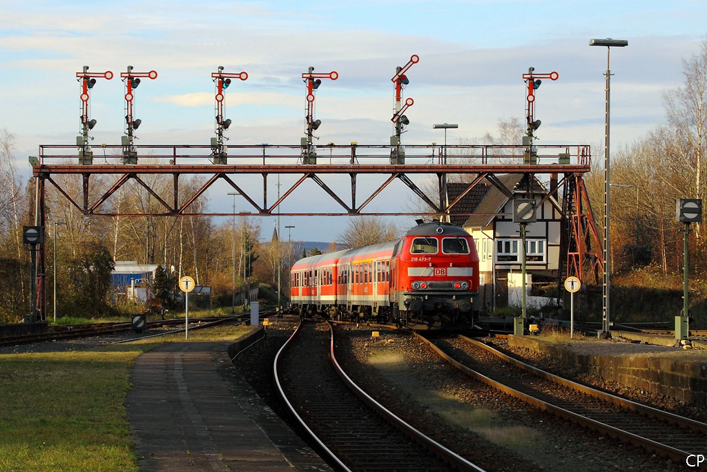 Mit dem RE nach Hannover verlsst 218 473-7 am 14.11.2010 den Bahnhof Bad Harzburg und passiert dabei die bekannte denkmalgeschtzte Signalbrcke.