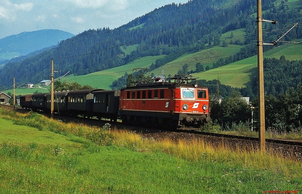 Mit einem Regionalzug ist 1041.18 bei Mandling am 23.08.1980 unterwegs. Die interessante Wagengarnitur war damals noch alltäglich.
