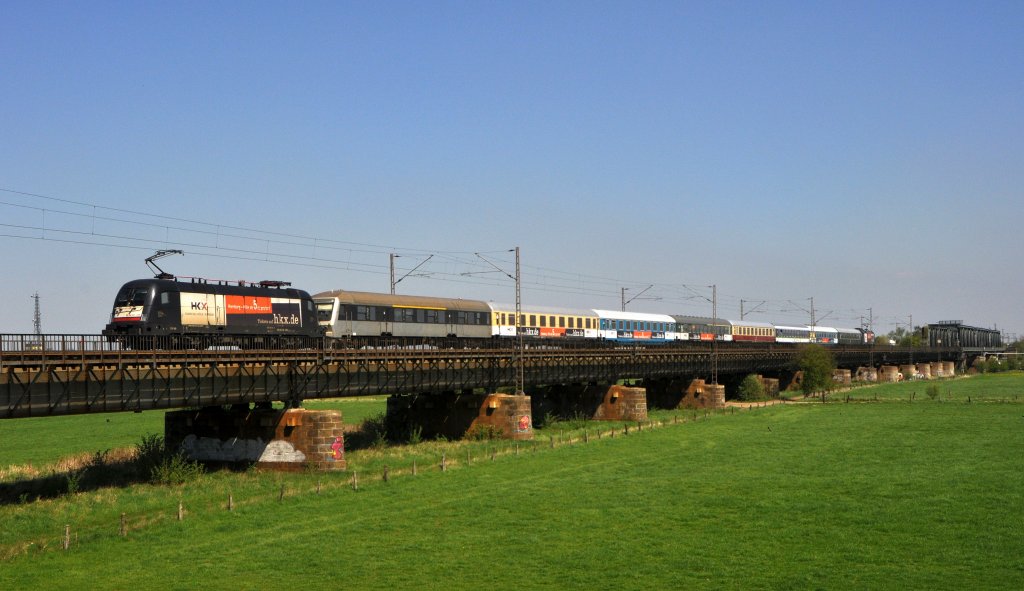 MRCE ES 64 U2-034 (182 534) und -036 (182 536 (am Schluss)), beide vermietet an OLA, sind am 04.05.13 mit dem aus einer kunterbunten Wagenmischung bestehenden HKX 1802 Hamburg-Altona - Köln Hbf auf der Weserbrücke bei Dreye unterwegs.