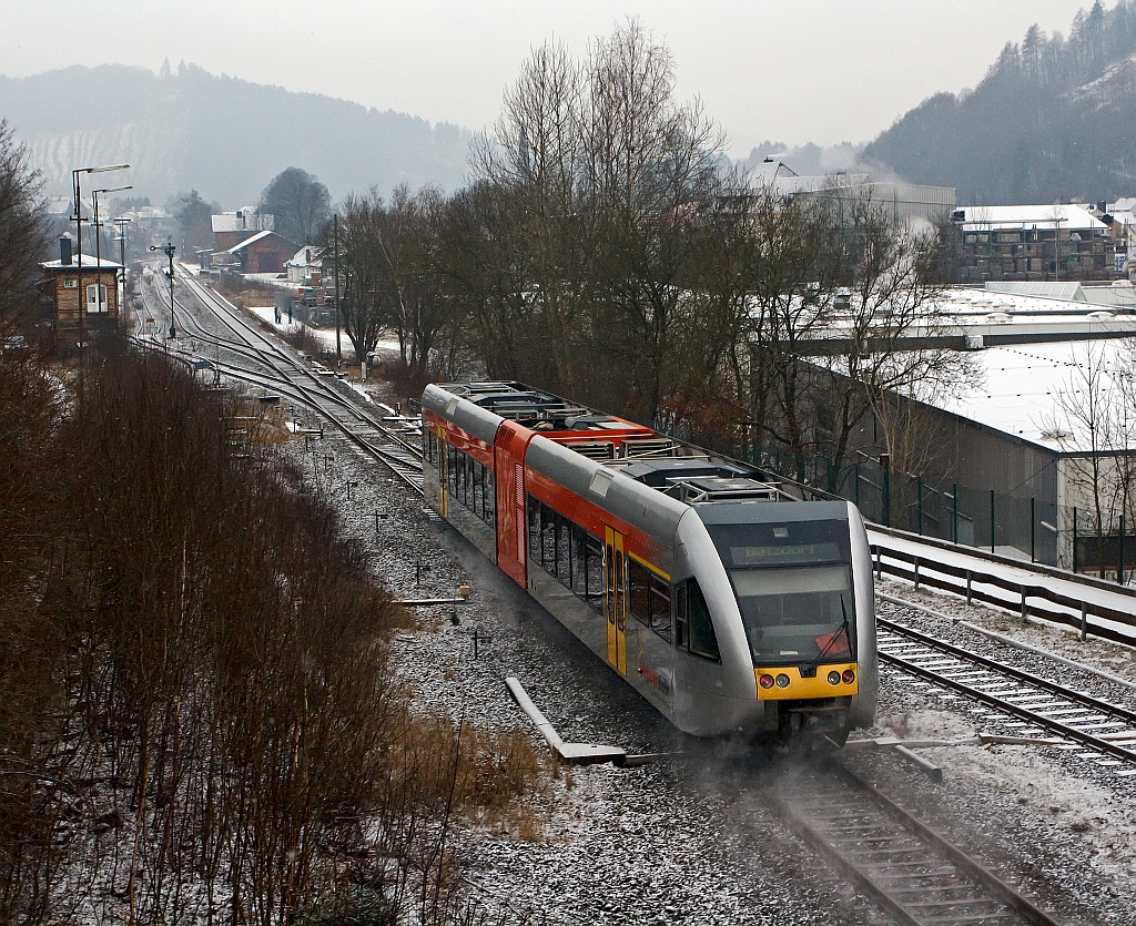 Nachschu: Stadler GTW 2/6 der Hellertalbahn kommt am 09.02.2012, bei ganz leichtem Schneefall, von Neunkirchen und fhrt gleich in den Bahnhof Herdorf ein. Danach fhrt er weiter in Richtung Betzdorf/Sieg, hier besteht dann Anschlu an den RE 9 (Rhein-Sieg-Express).
Links das Stellwerk Herdorf Ost (Ho). ganz hinten links das Stellwerk Herdorf Fahrdienstleiter (Hf). Hinten rechts der Gleise der Bahnhof, davor der ehem. Gterbahnhof.